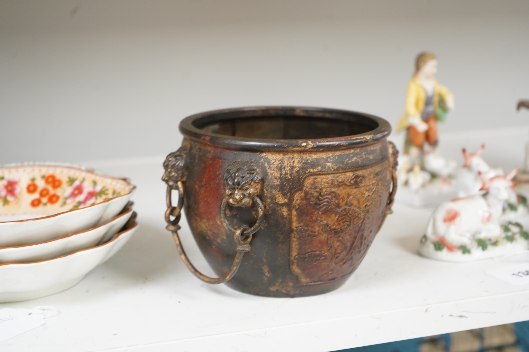 A Chinese partially gilt bronze censer, decorated in relief with twin handles, 16cm in diameter